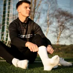 Fußballer zieht Gripsocken an